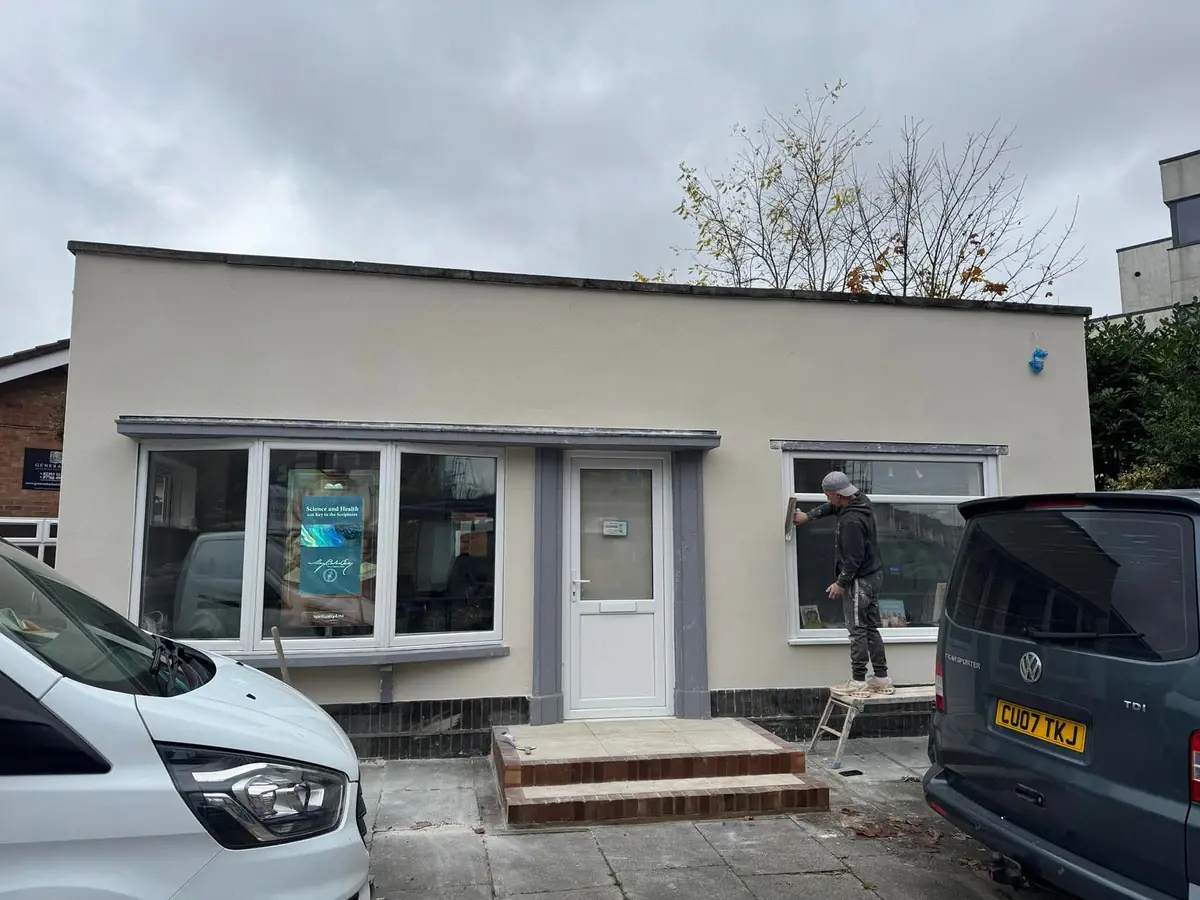 Ian floating a render coat on a shopfront